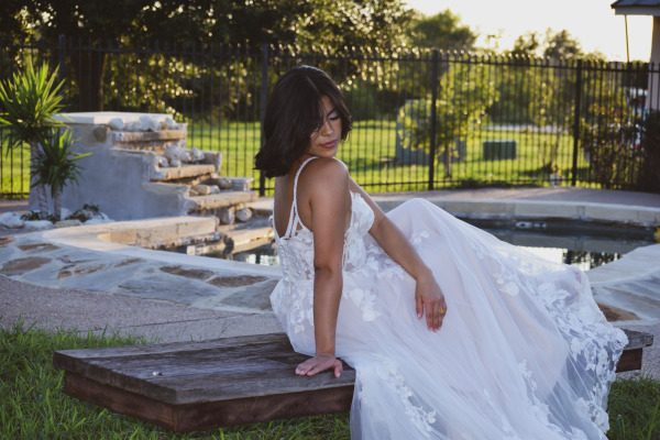 A bride looks down her shoulder outside
