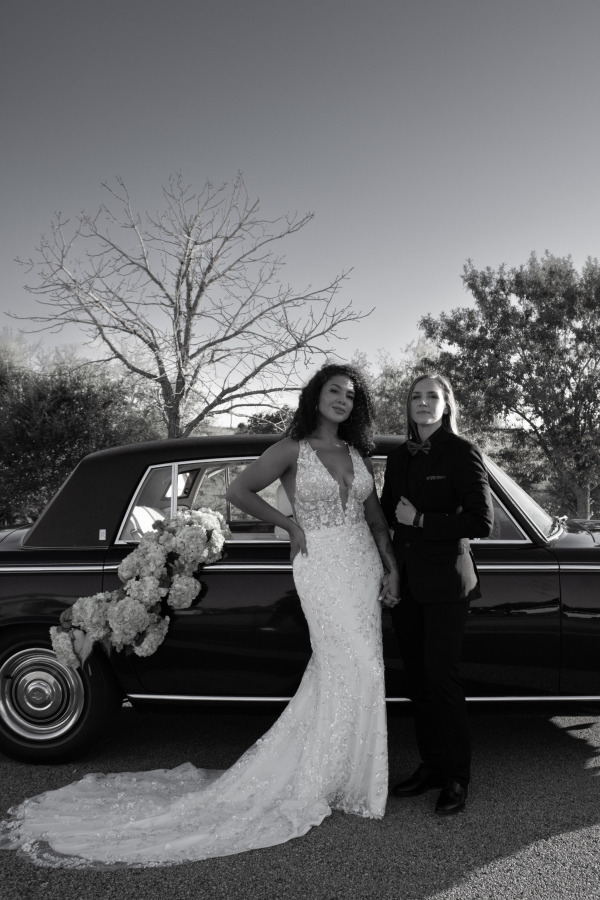A woman couple posing by a car