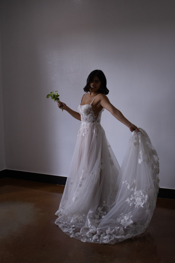 A bride holding her dress and smiling
